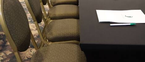 A conference room with a long table, chairs, water bottles, and papers.