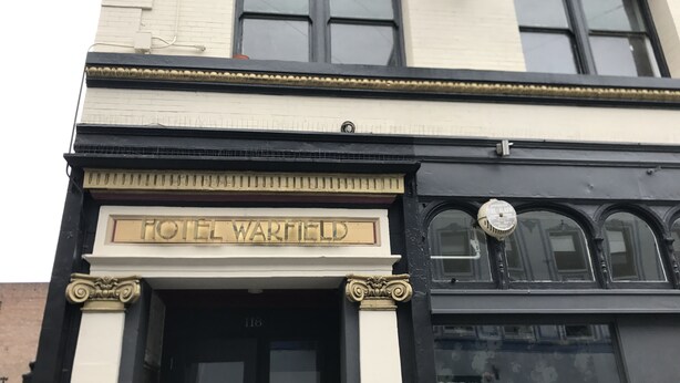 The exterior of Hotel Warfield, featuring a classic architectural design with a prominent entrance and a signboard. - Warfield Hotel (San Francisco)