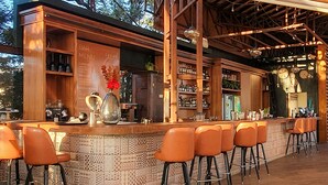 Angolo bar con bancone in legno, sgabelli da bar e bacheca dei menu.