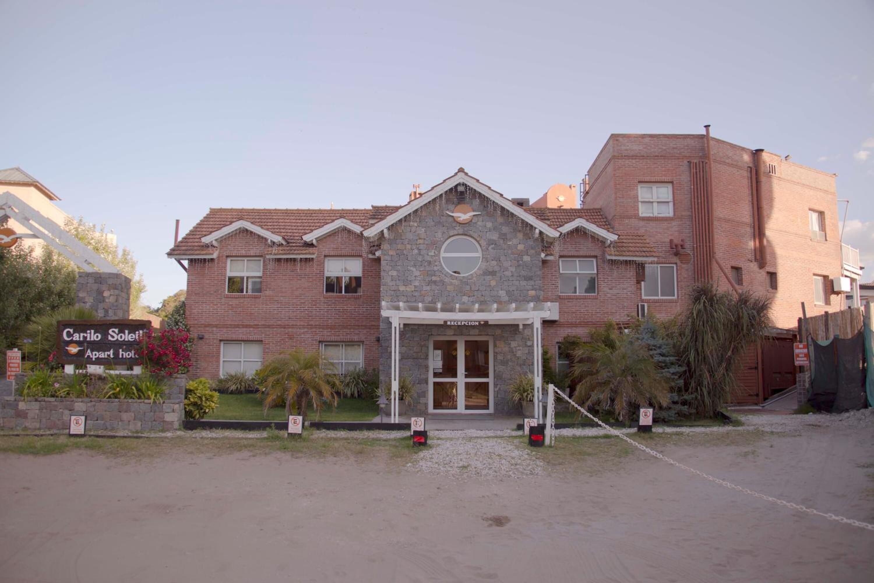 Un edificio de dos plantas con fachada de piedra y una zona de recepción.