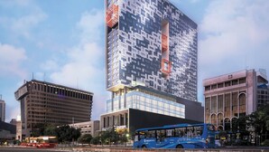 Un moderno edificio de gran altura con una fachada distintiva, rodeado de otras construcciones urbanas.