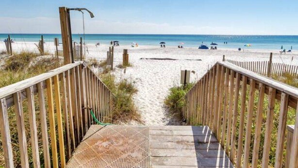 A wooden boardwalk leading to a sandy beach with a clear view of the ocean. - Eastern Shores on 30A by Panhandle Getaways (Santa Rosa Beach)