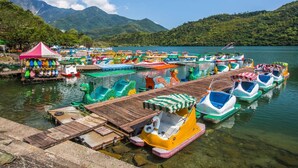 Un muelle con coloridos botes a pedal y un pequeño pabellón.