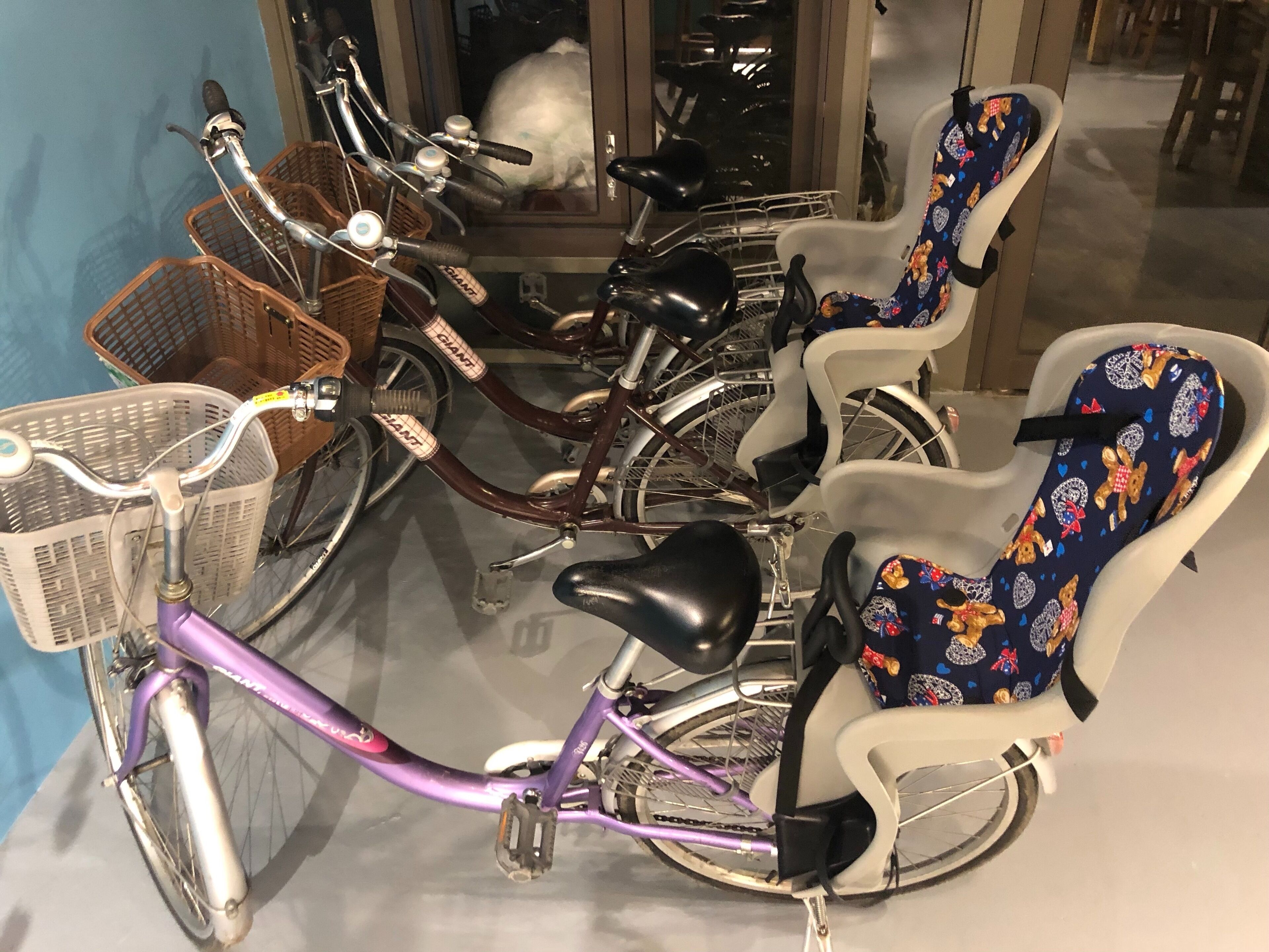 Una bicicleta púrpura con una cesta y un asiento para niño.
