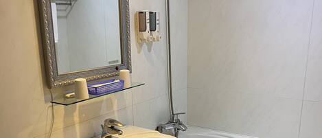Un baño con inodoro, lavamanos, espejo y bañera.
