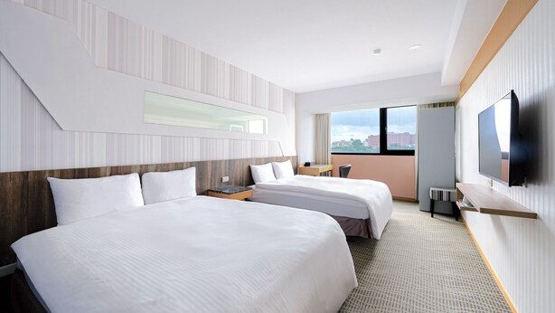 A hotel room with two beds, a TV, a desk, and a window with a city view. - Sunny Hotel (Taipei)