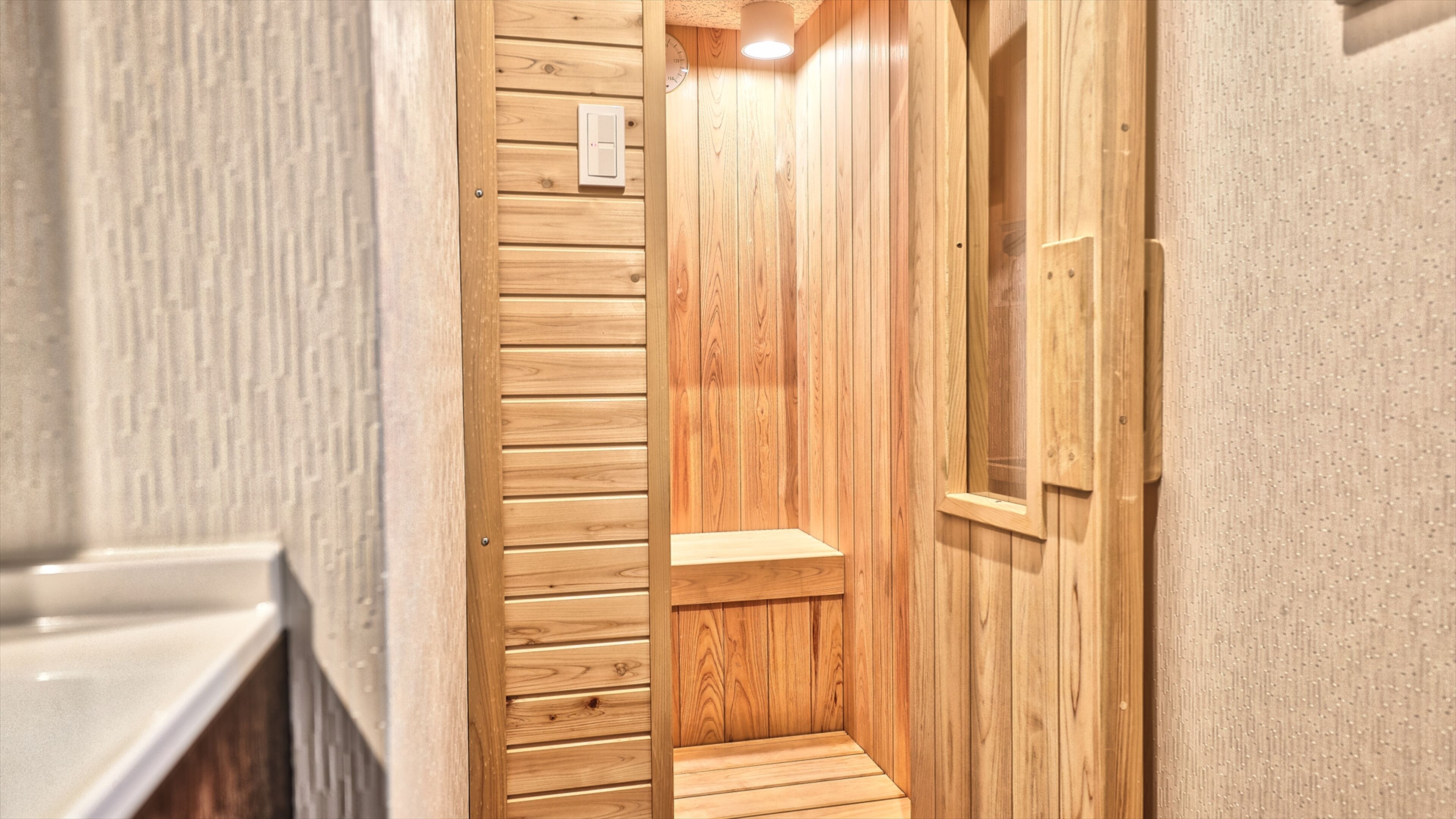A wooden interior hallway with a wooden door, a light switch, and a small shelf.