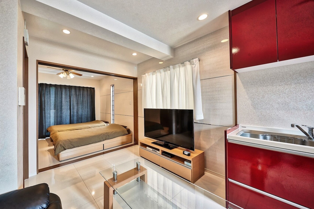 Una habitación de hotel moderna con cama, televisión y kitchenette.