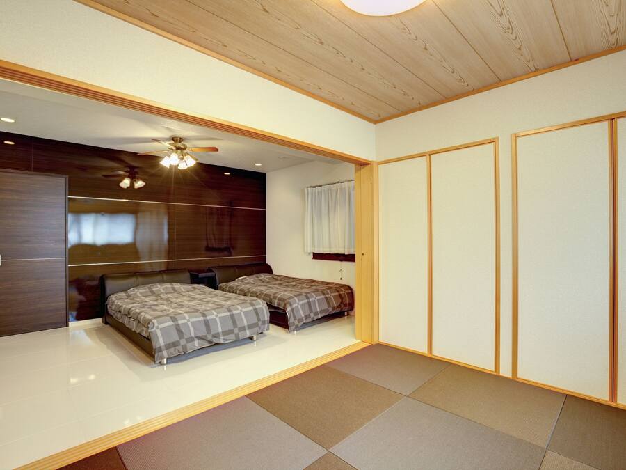 Una camera da letto con due letti, un ventilatore a soffitto e una porta scorrevole.