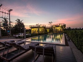 Una piscina al aire libre, sillones reclinables de piscina