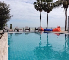 Una piscina al aire libre, tumbonas