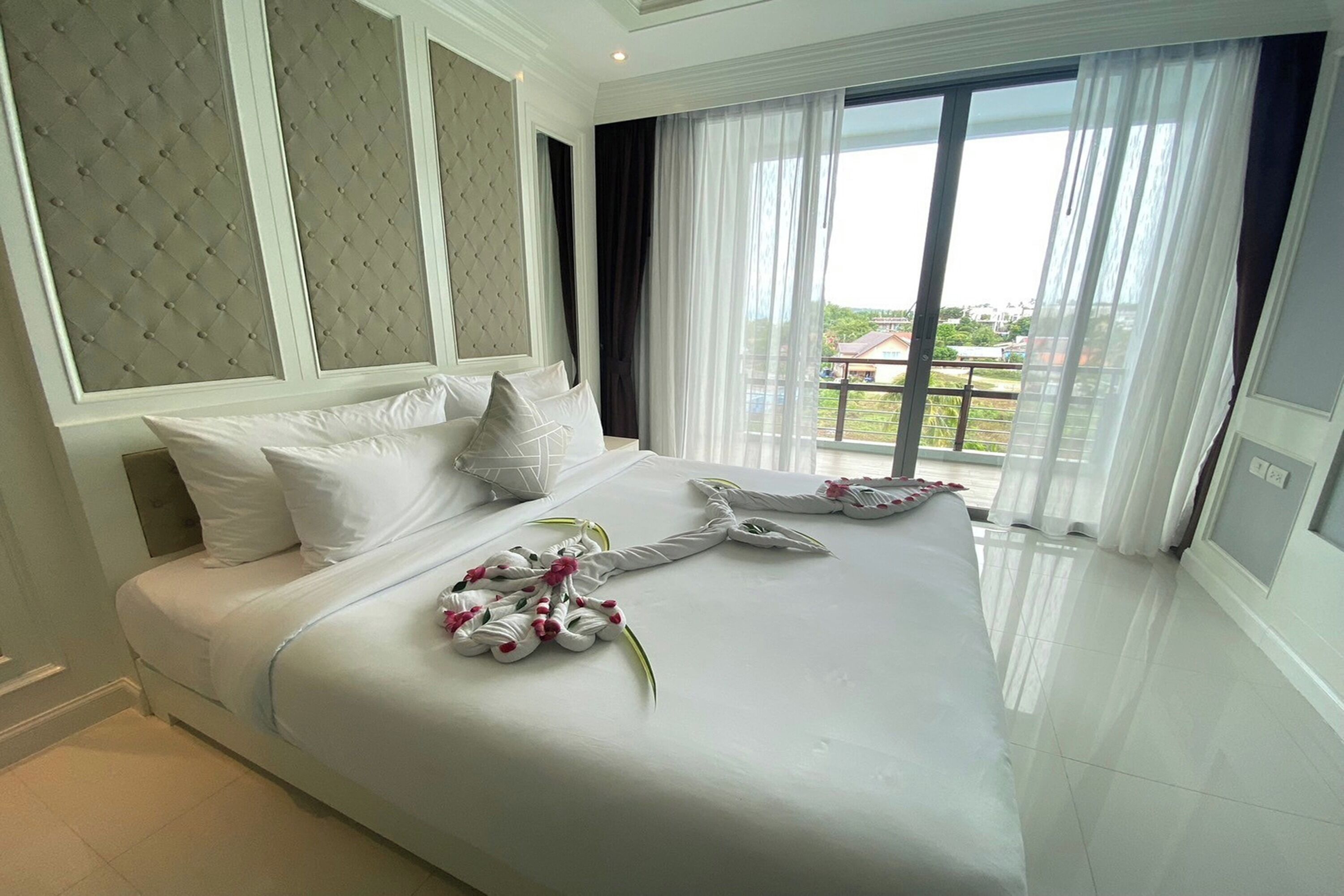 A hotel room with a large bed, a view of the outdoors through a large window, and a modern design.
