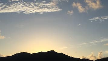 Silueta de una cadena montañosa contra un cielo despejado con algunas nubes.