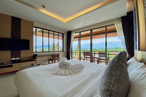 Habitación de hotel con una cama grande, un televisor de pantalla plana, un escritorio y vistas al exterior.