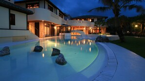 A modern resort with a large swimming pool, multiple guest rooms, and a well-lit outdoor area. - La Casa Panacea Okinawa Resort (Onna)