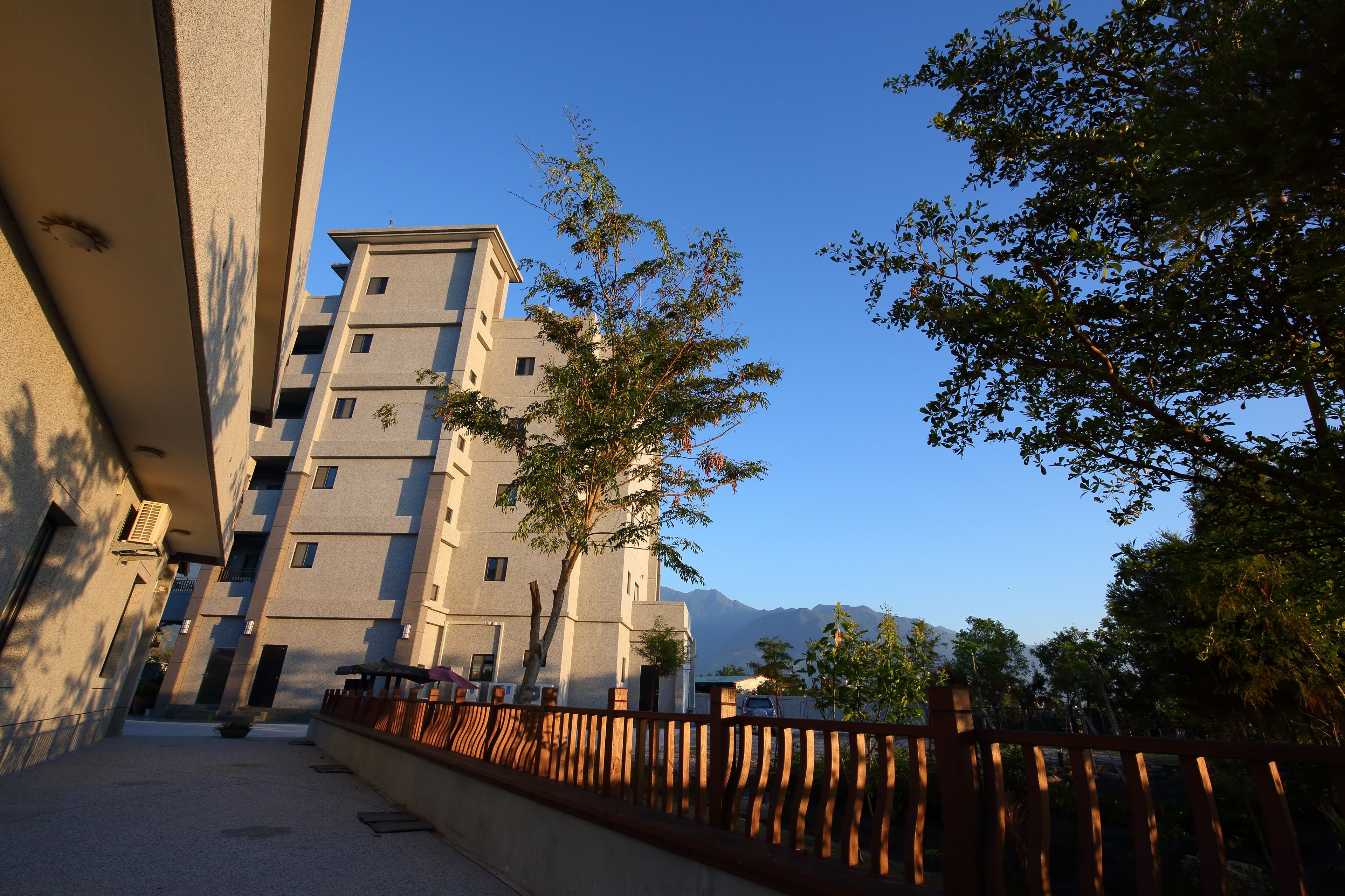 A multi-story building with a modern architectural style, featuring balconies and a courtyard.