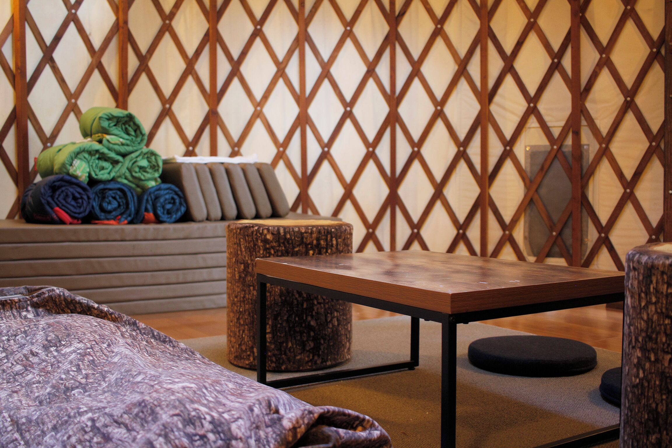A room with a wooden table, a sofa, and a decorative lattice wall.