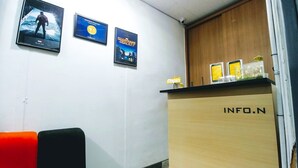A reception area with a wooden counter labeled "INFO.N" and three movie posters on the wall. - Hause Itaewon - Hostel (Seoul)