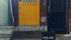 A building with a sign reading "HAUSE GUEST HOUSE" and another sign for "polygon lab". - Hause Itaewon - Hostel (Seoul)