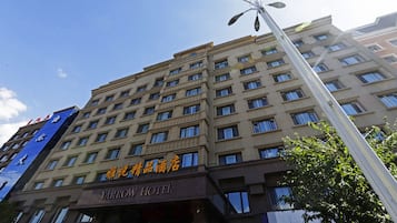 Un edificio de hotel de varios pisos con un letrero que dice 'Yarrow Hotel' y otro letrero en un idioma extranjero.