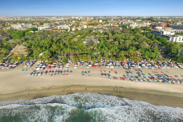 An aerial view of a beach with numerous umbrellas and people. - Legian Beach Villas (Legian)