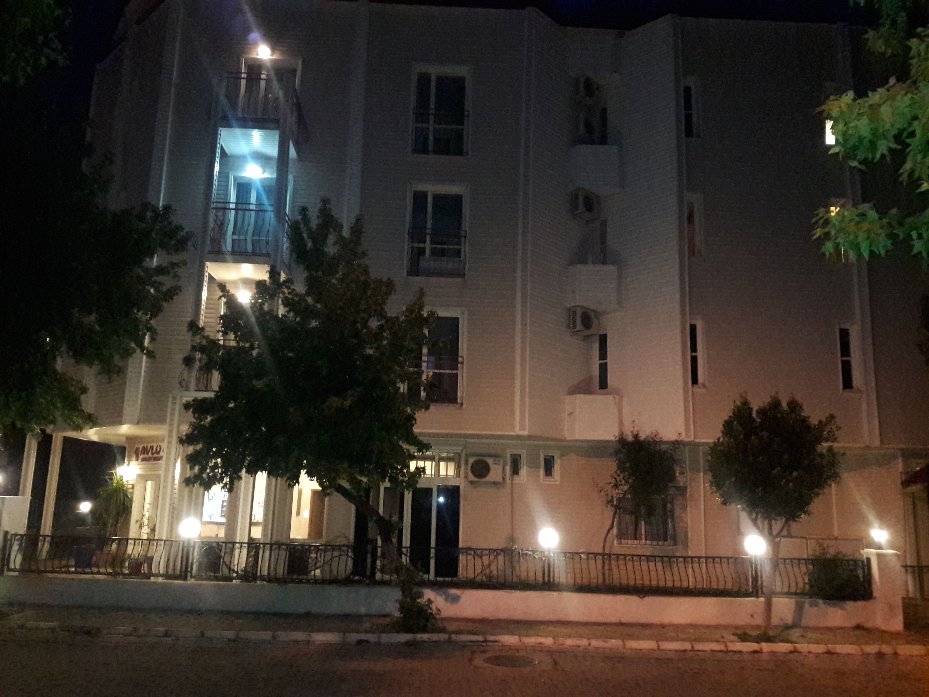 Un edificio de varios pisos con una entrada destacada y un balcón.