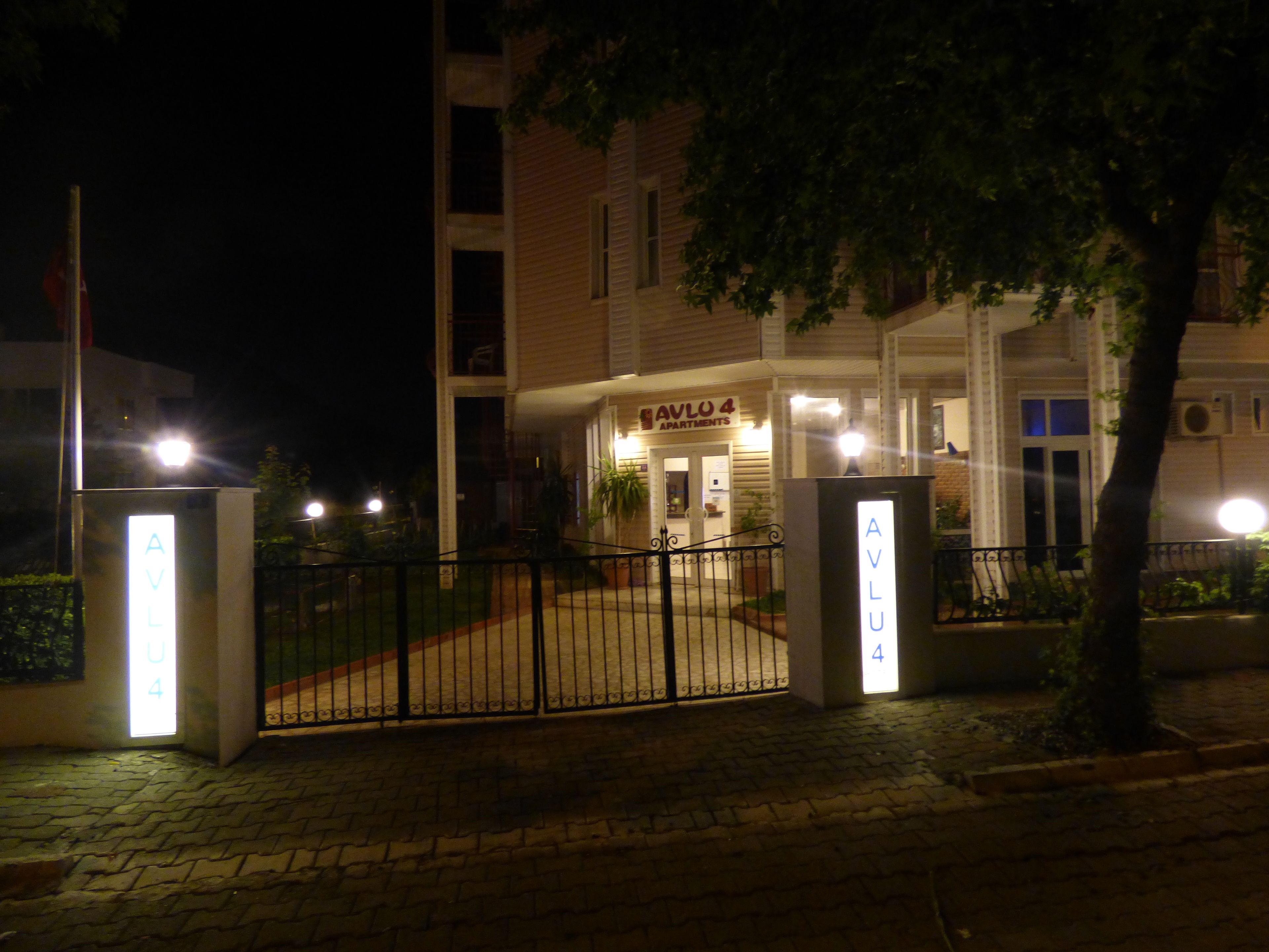 Ein begrenzter Zugang zu einem Gebäude mit einem Schild, auf dem 'AVLU 4 APARTMENTS' steht.
