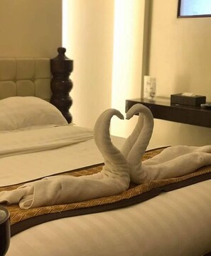 A hotel room with two beds, one of which has a towel arranged in the shape of a heart. - F8 Bed and Breakfast (Tagaytay)