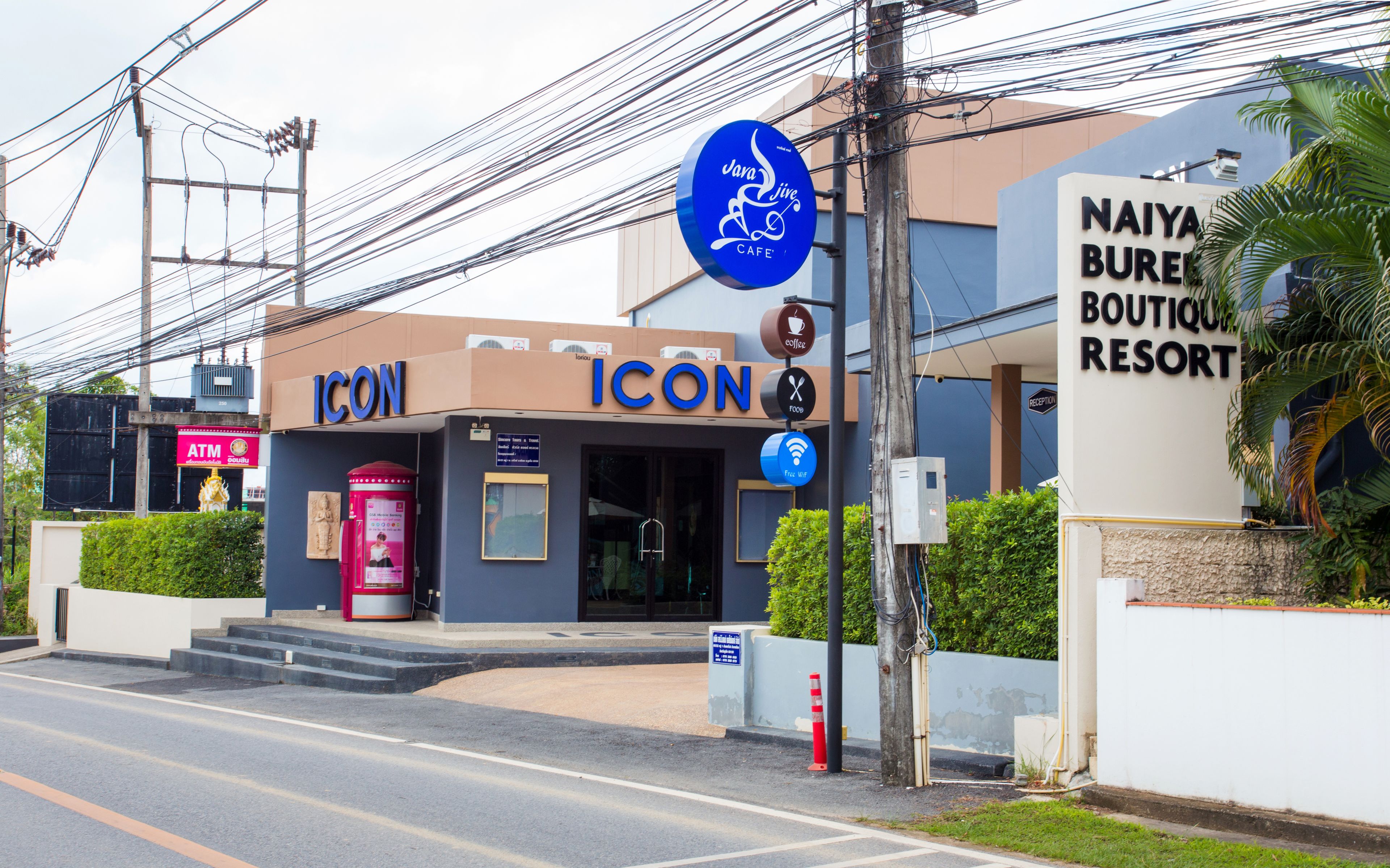 Un edificio con un letrero que dice "ICON" y otro letrero que anuncia "NAIYA BUREAU RESORT".