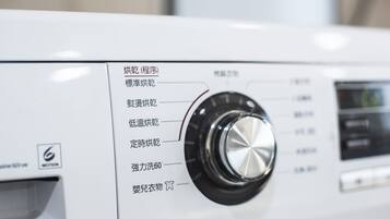 Una lavadora con un selector y etiquetas en un idioma extranjero.