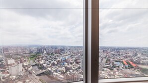 Panoramisch uitzicht vanuit een hoog raam op een dichtbevolkt stedelijk gebied met een rivier erdoorheen.