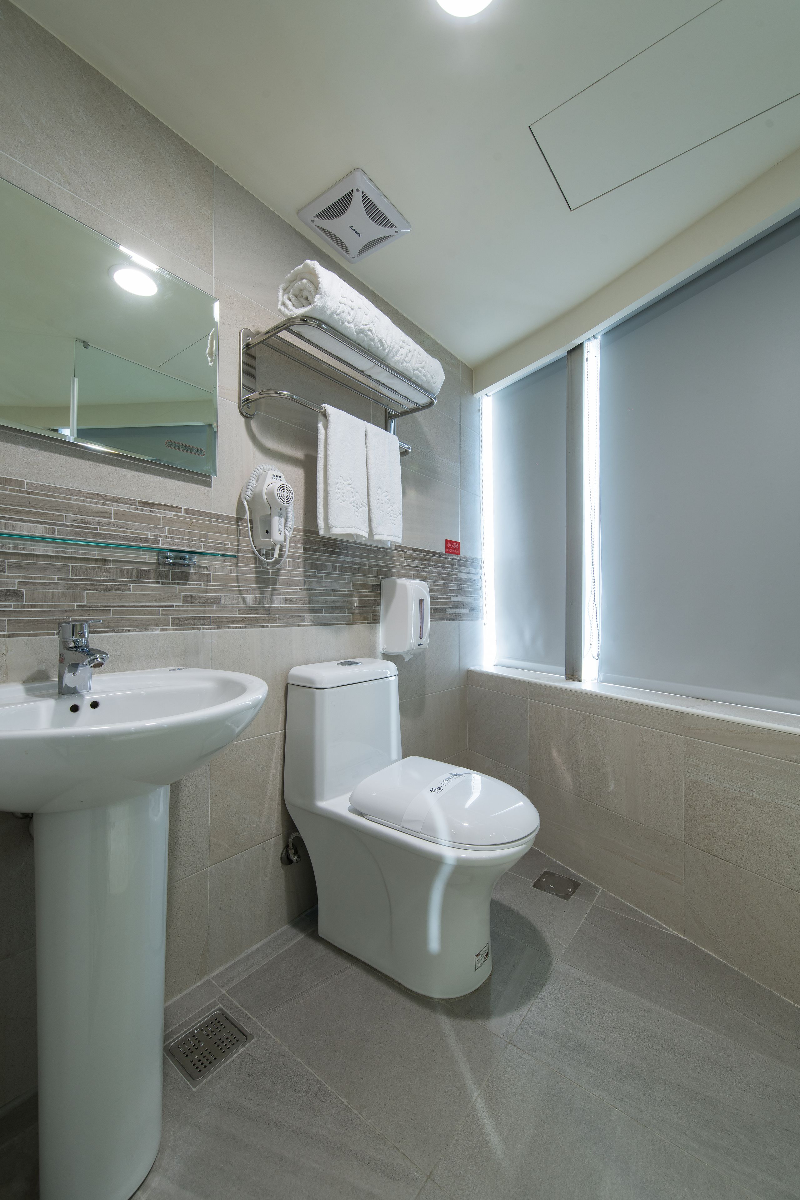 Un baño moderno con lavamanos, inodoro y espejo.