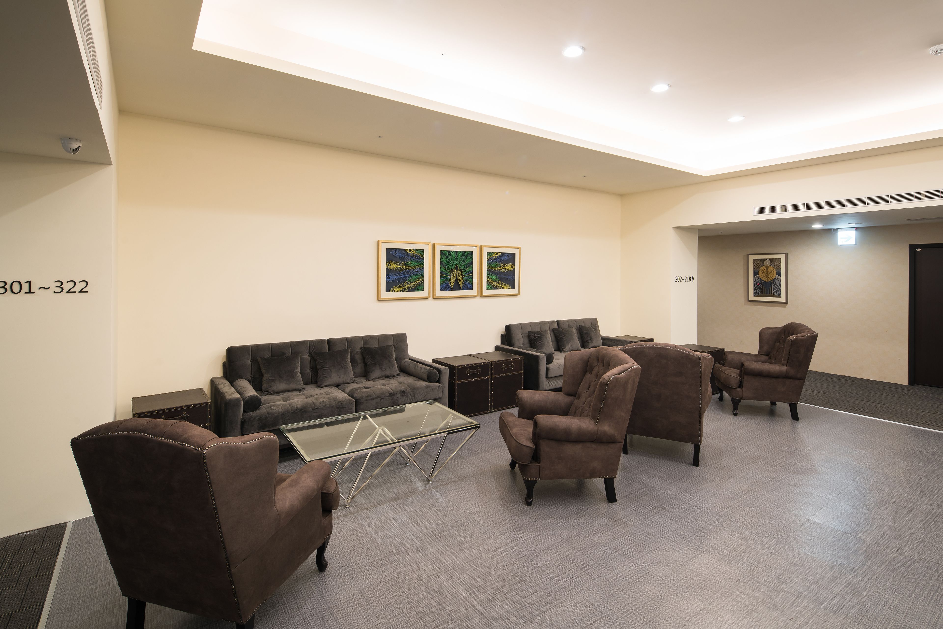 Un área de estar moderna con sofás, sillones y una mesa de centro.