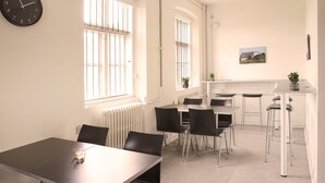 Une cuisine moderne avec des meubles blancs, un plan de travail noir et un coin bar équipé de tabourets.