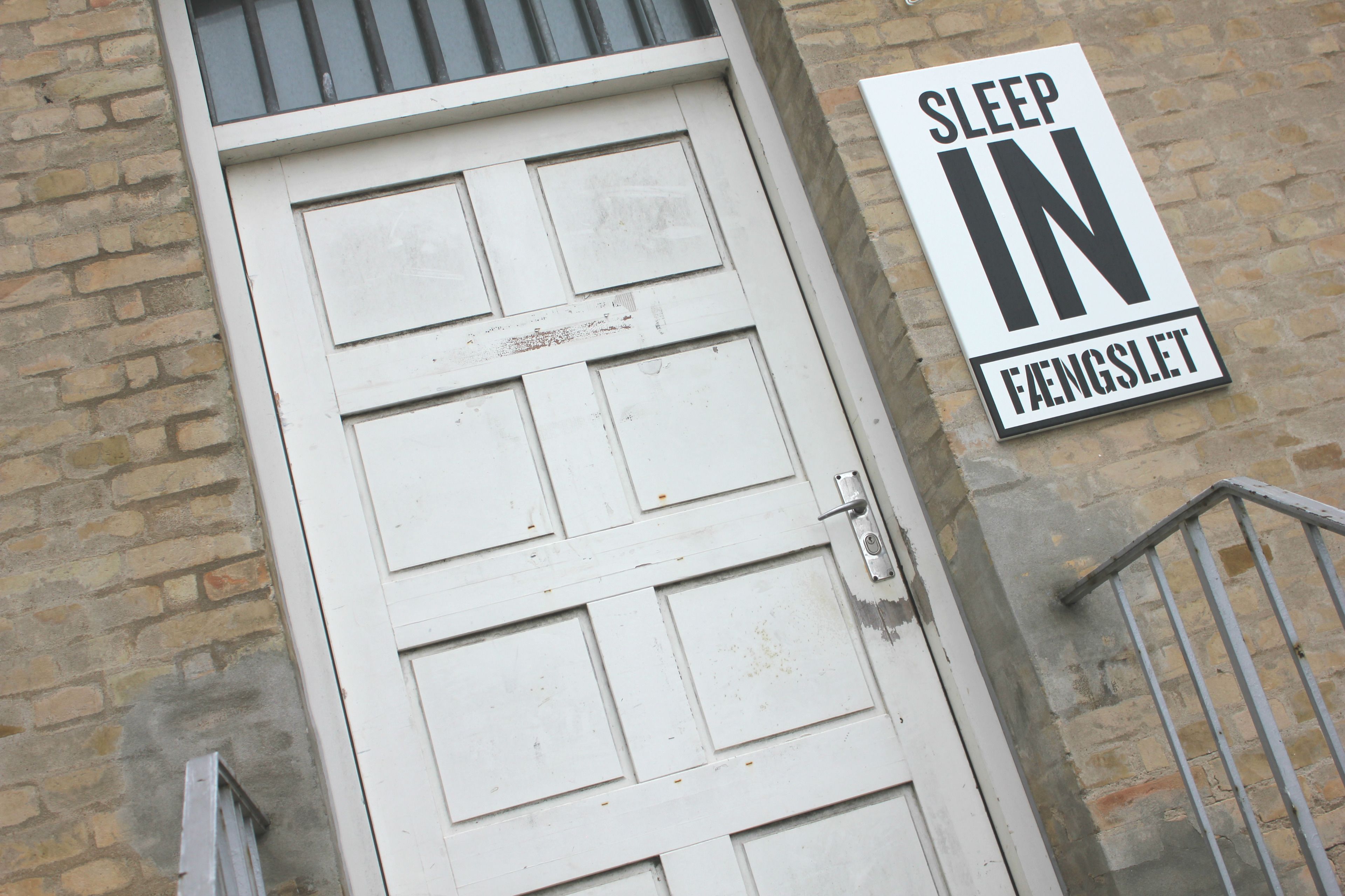 Una puerta blanca con un letrero que dice 'SLEEP IN FAENGSLET'.