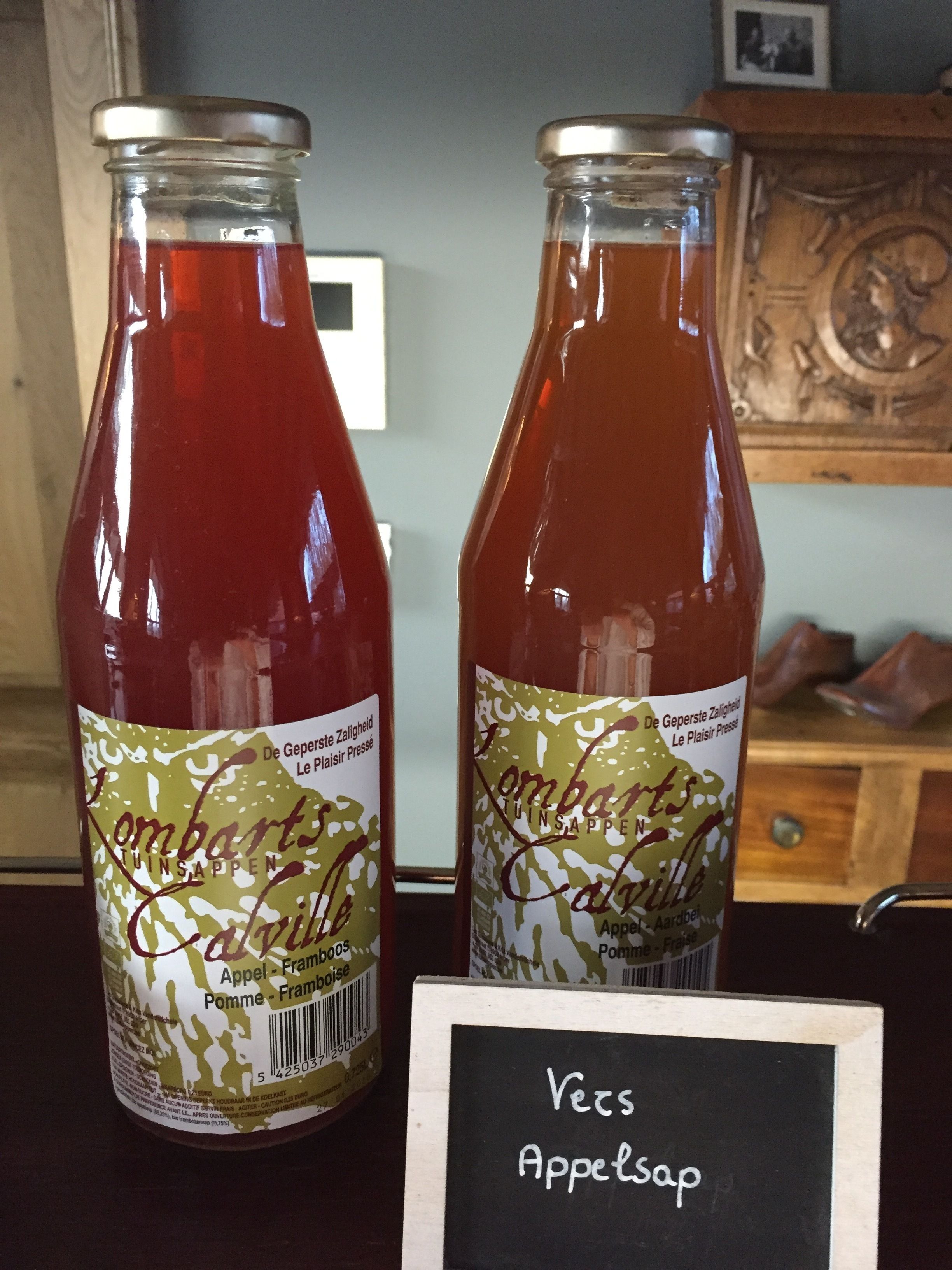 Deux pots de confiture « Tunsappen », dont les étiquettes indiquent « Pomme-Framboise » et « Pomme-Framboise ». Un panneau devant indique : « Vers le jus de pomme ».