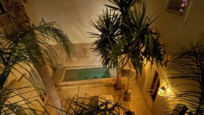 A pool area with a hot tub, surrounded by palm trees and a staircase. - Riad 144 (Marrakech)
