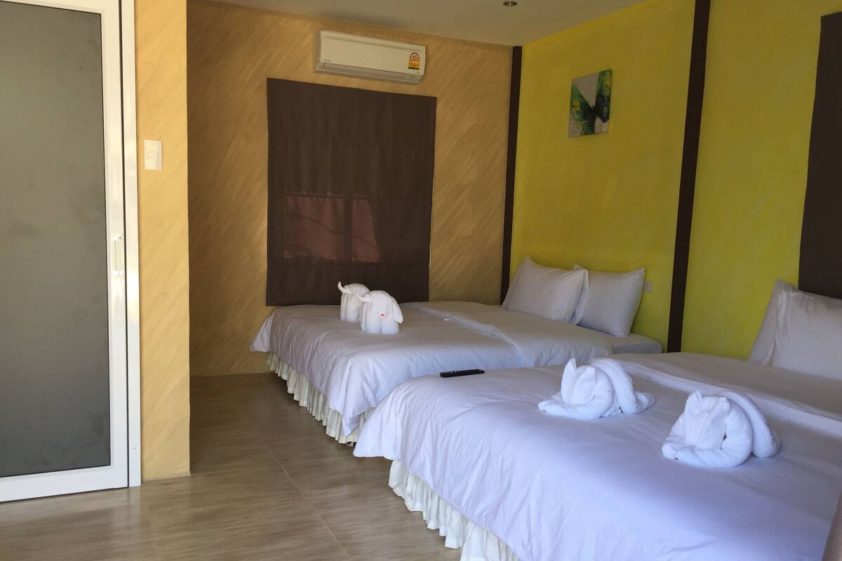 A hotel room with two beds, each with white bedding and towels.