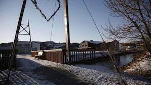 A snowy outdoor area with a heart-shaped decoration on a metal structure, a wooden fence, and a building in the background. - Bjugn Hotell (Orland)