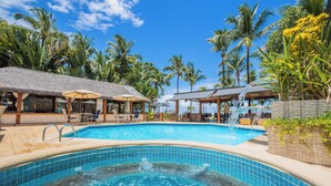 A swimming pool with a hot tub, surrounded by palm trees and lounge chairs. - Pousada da Torre (Cairu)