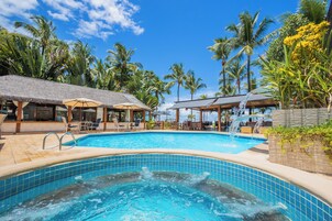 Una piscina al aire libre, sillones reclinables de piscina