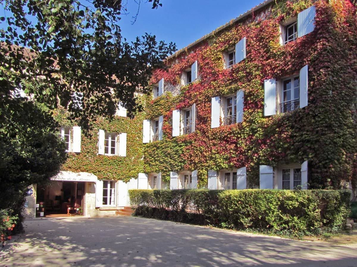 Un edificio con entrada techada y camino de acceso pavimentado.