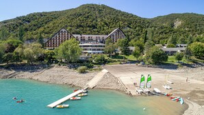 A coastal hotel with multiple buildings, a pier, and boats. - Village Club les Hyvans (Chorges)