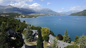 A lake with boats, surrounded by mountains and residential buildings.