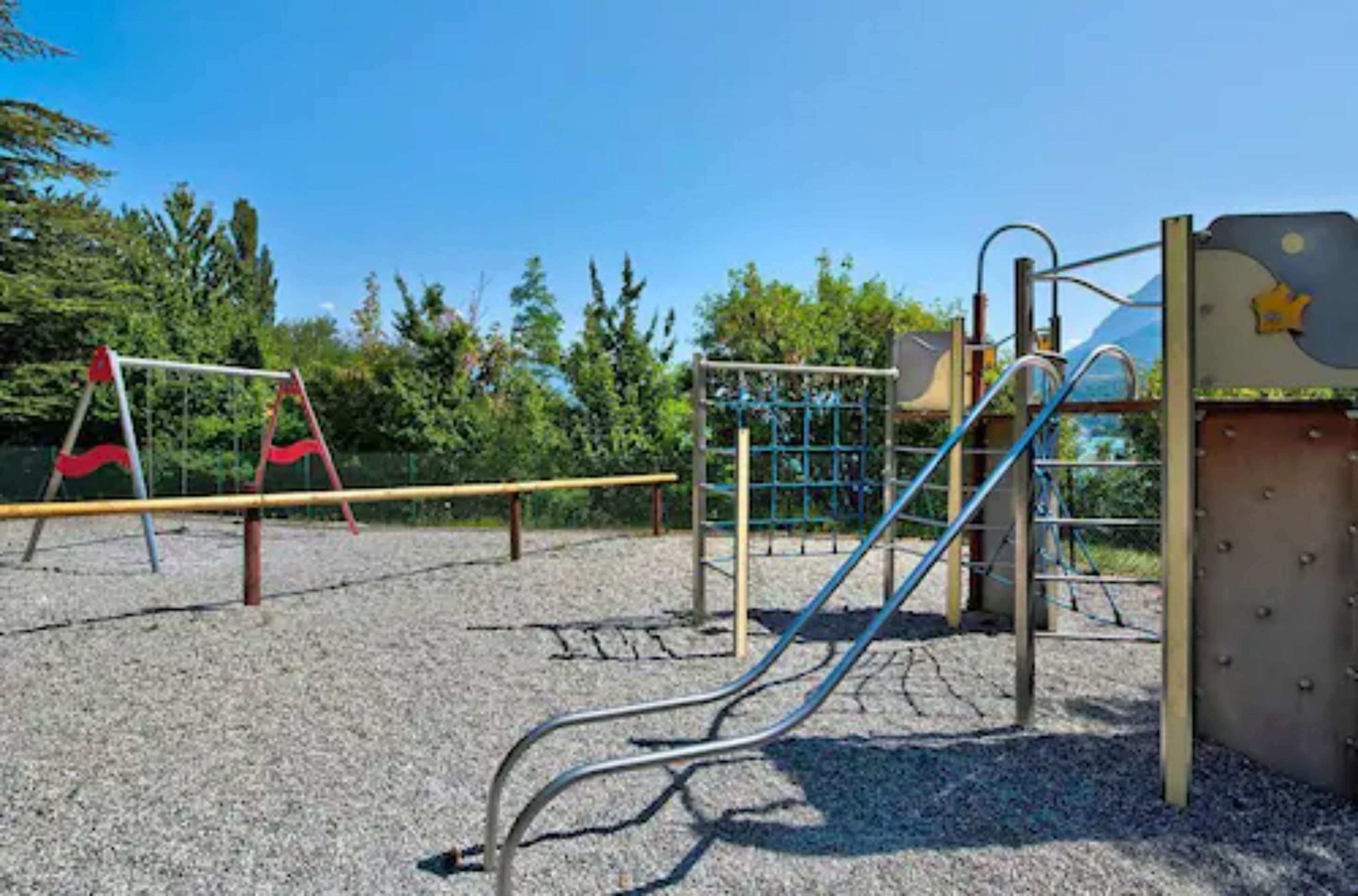 A playground with a slide, climbing structures, and a swing set.