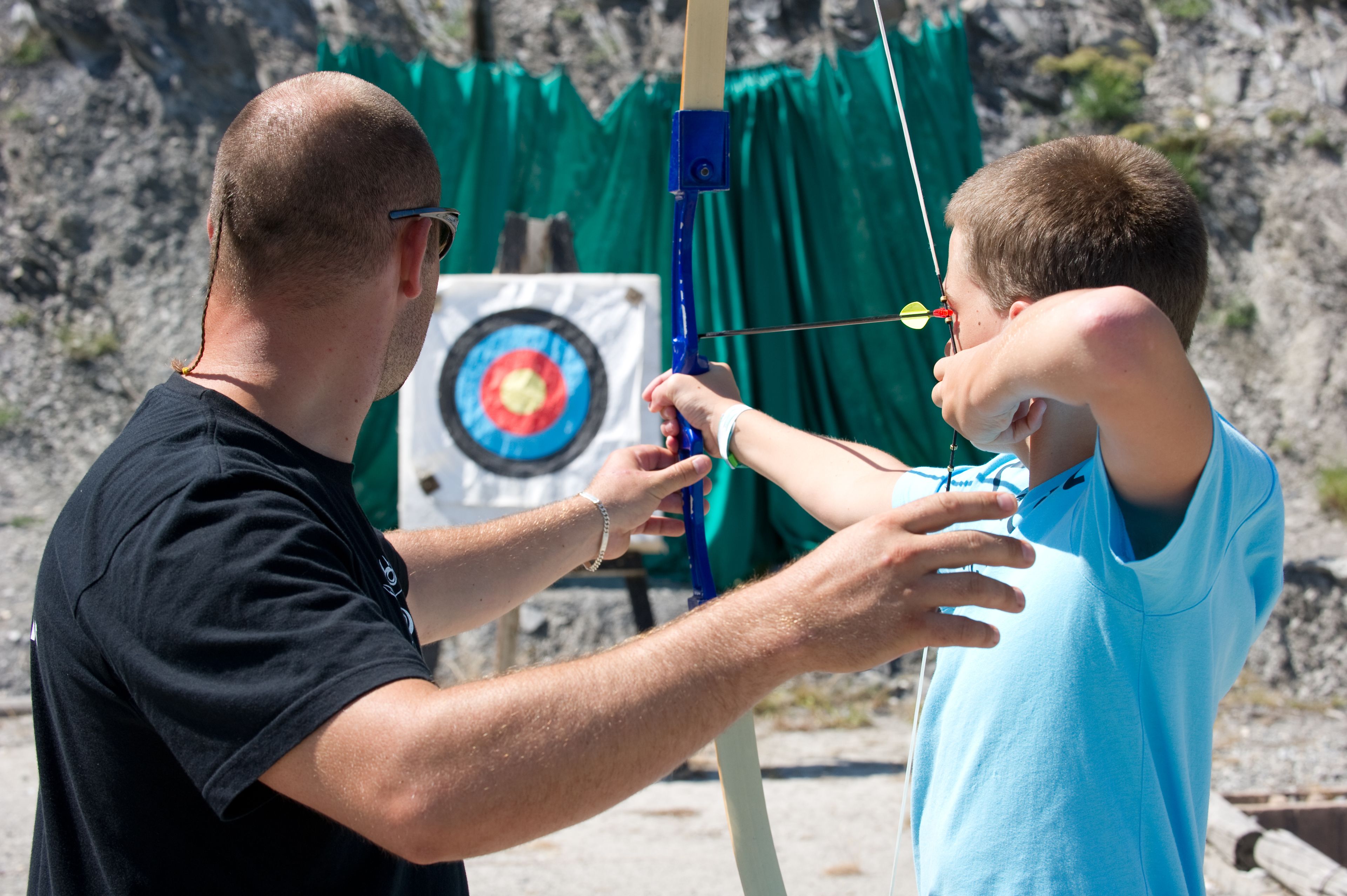 A person aiming an arrow at a target.