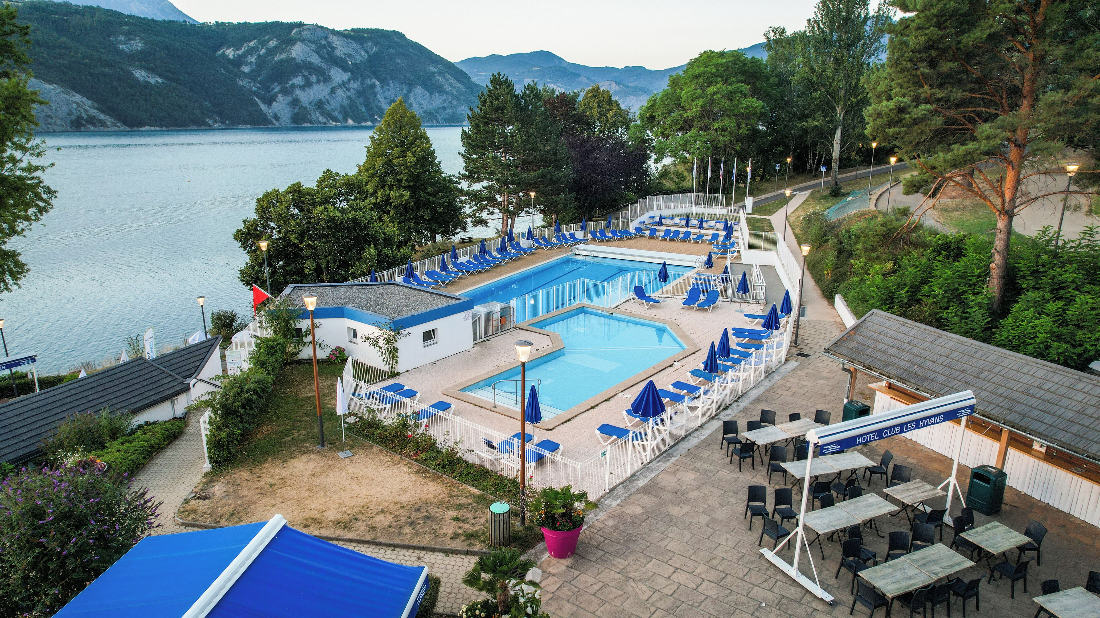 Un hôtel doté d’une piscine, d’un espace extérieur aménagé et offrant une vue sur un lac.