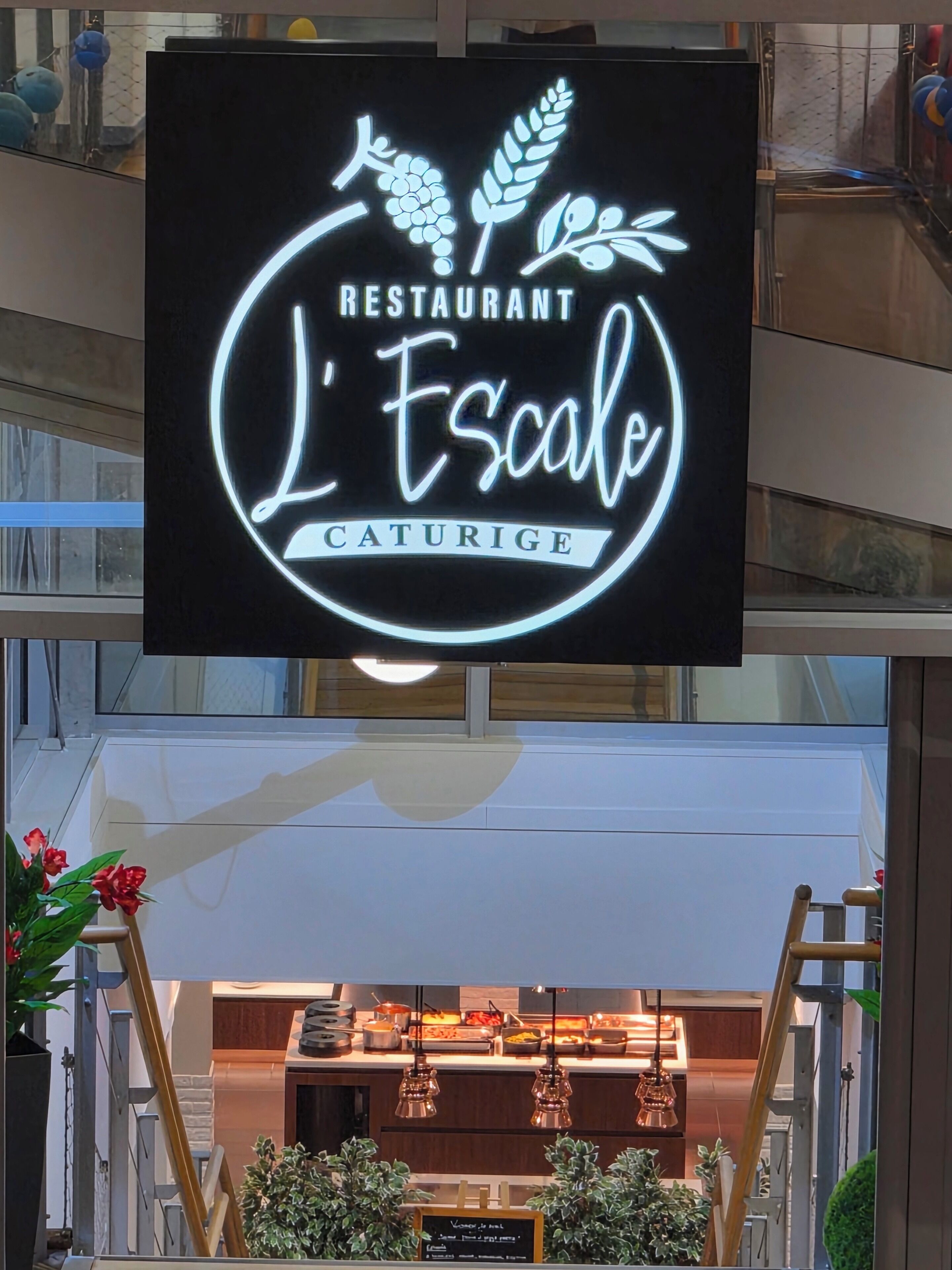 A restaurant sign with a circular logo and the name 'L'Escale'.