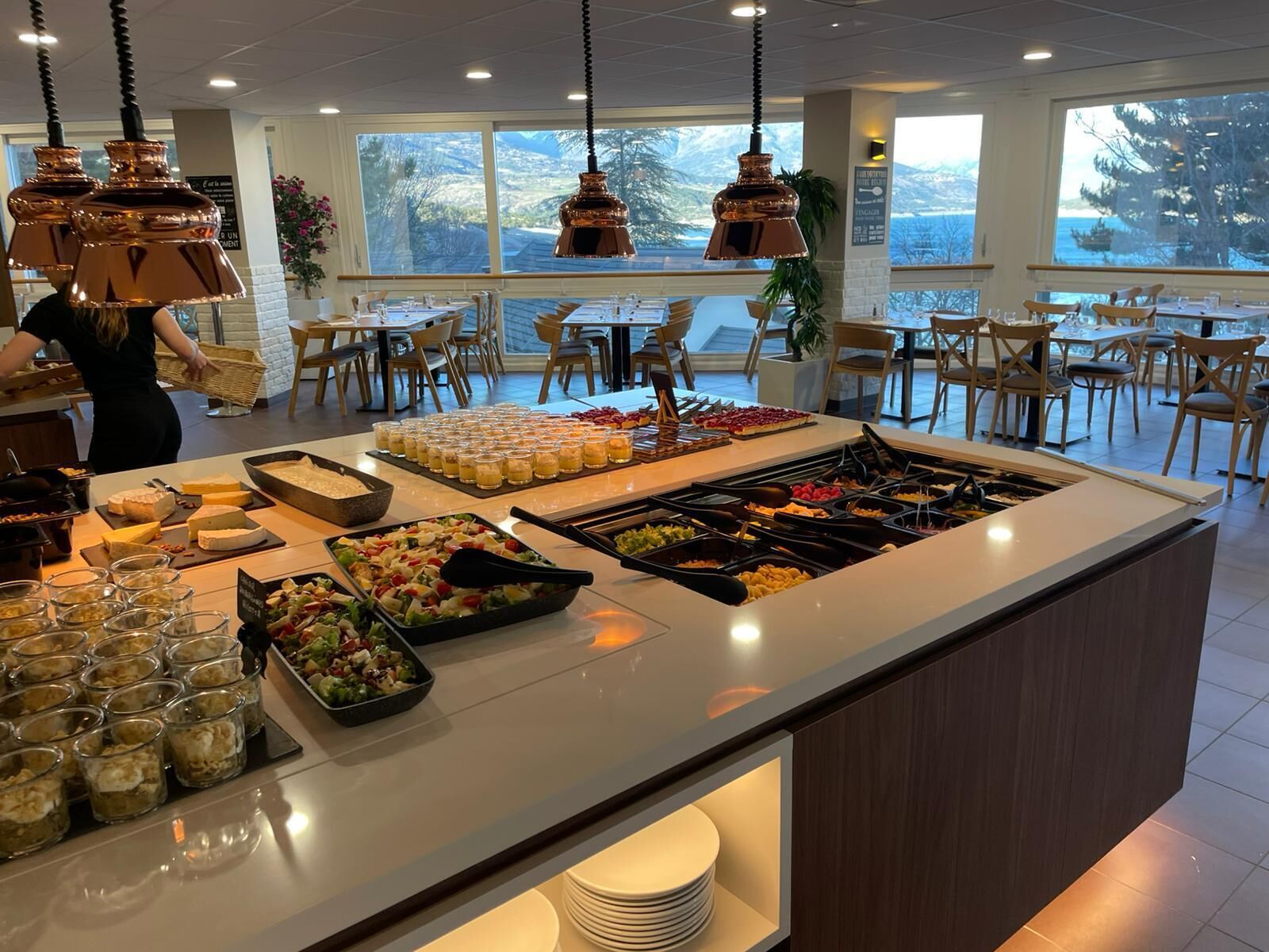 A buffet with various food items and drinks, a bar area, and seating arrangements.