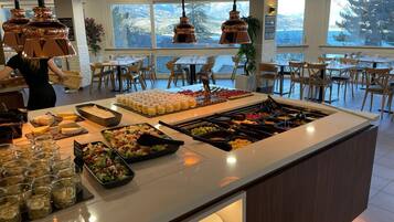 A buffet with various food items and drinks, a bar area, and seating arrangements.
